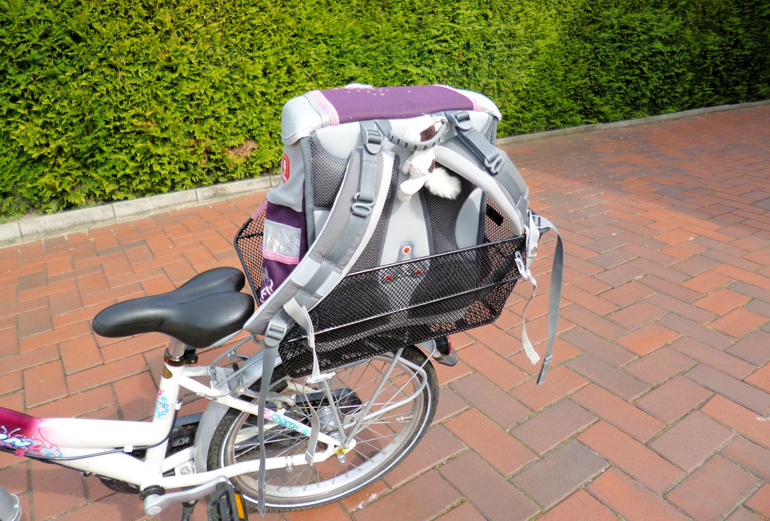 Kinderfahrrad mit Schultasche auf dem Schulweg